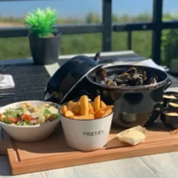 Portie mosselen met een salade, friet, remouladesaus en cocktailsaus